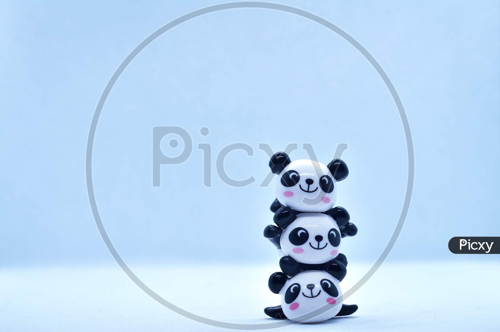 Little Panda Stacked Porcelain Figurines Isolated On Black Background
