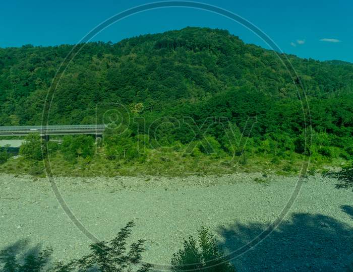 Italy,La Spezia To Kasltelruth Train, A Body Of Water Surrounded By Green Grass And Trees