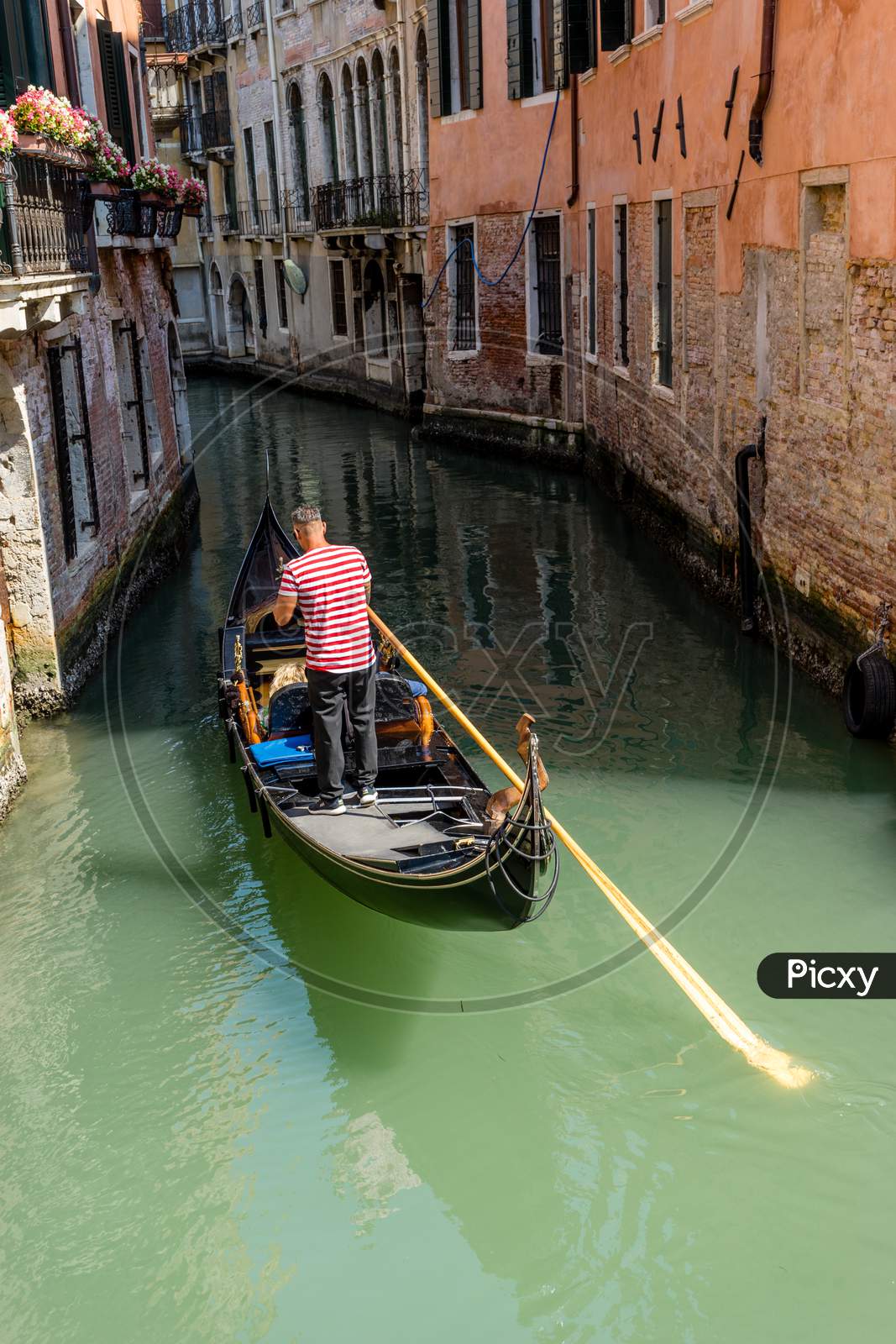 Italy, Venice, Gondolier Navigating A Gondola Near San Moise On A Canal