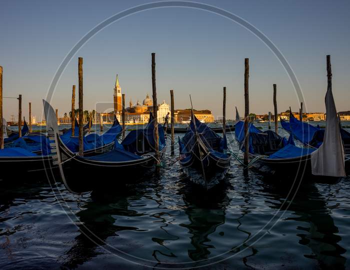 Gondolas Moored By Saint Mark Square With San Giorgio Di Maggiore Church In The Background In Venice, Italy