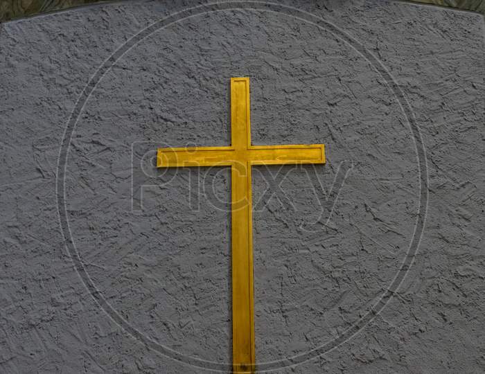 Golden Holy Cross Against Pale Blue Background