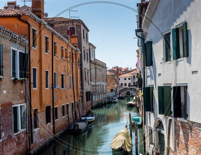 Italy, Venice, A Narrow City Street With Buildings In The Background