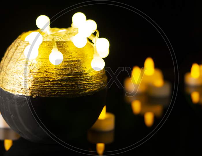 Colourful mini clay pot arrangement on dark background with led lights