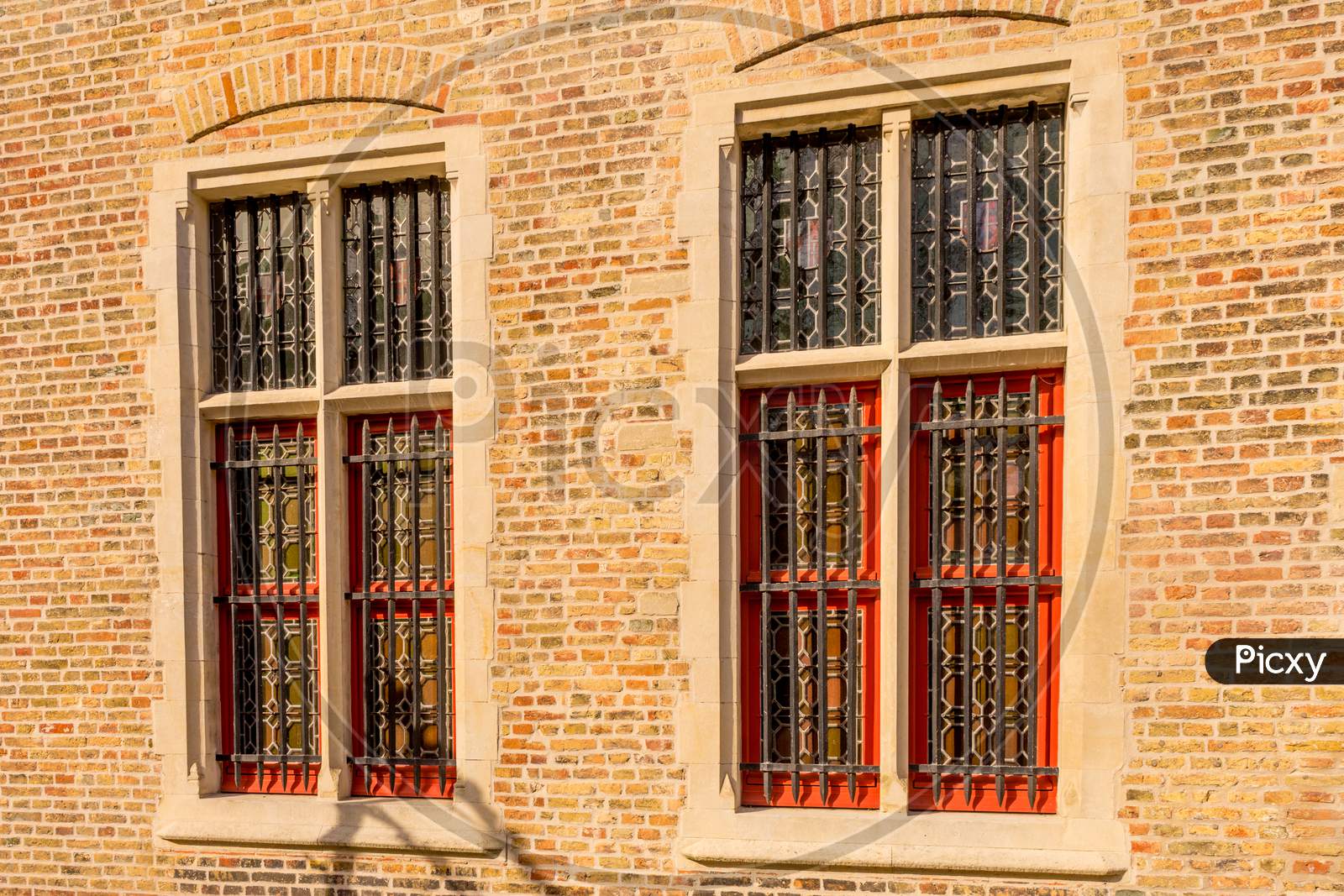 Belgium, Bruges, A Close Up Of A Brick Building With Grilled Windows