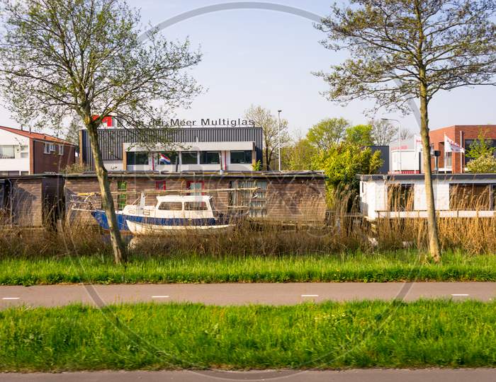Leiden, Netherlands - 22 April 2018:  Coloured Boats Parked On A Canal Outside The Van Der Meer Building