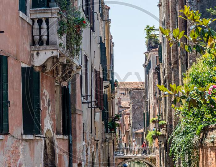 Italy, Venice, A Narrow City Street With Old Buildings In The Background
