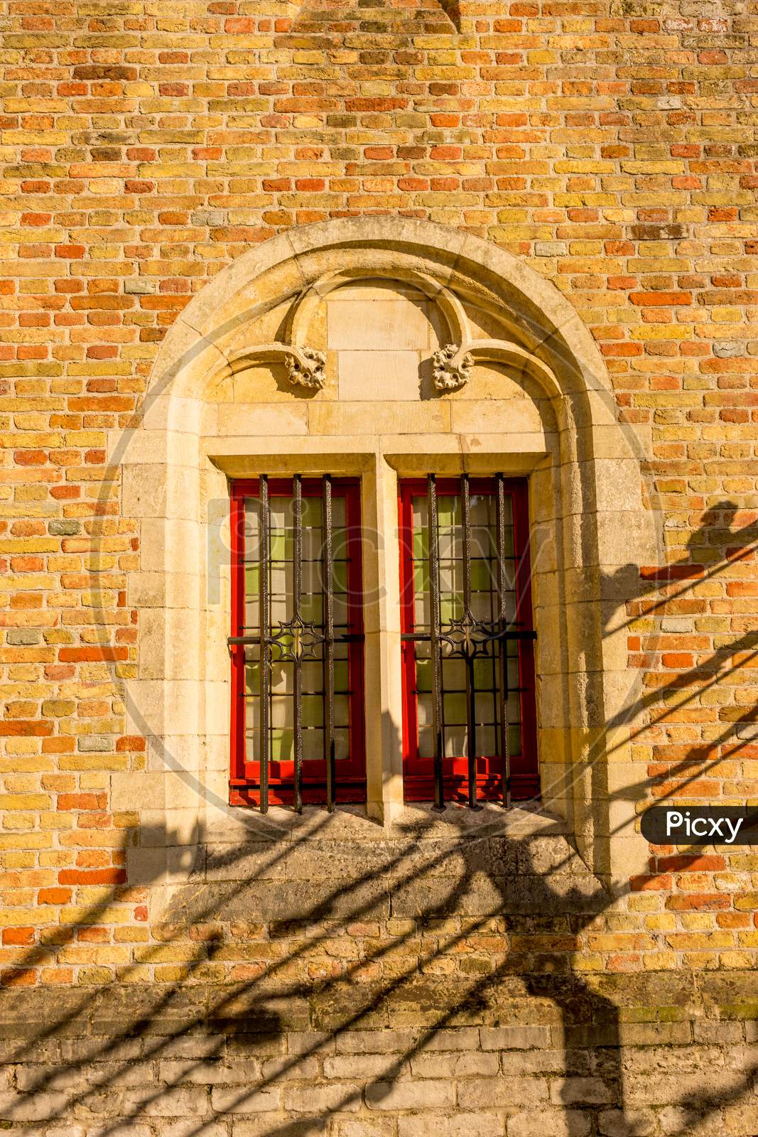 Belgium, Bruges, Grilled Window On A Brick Wall