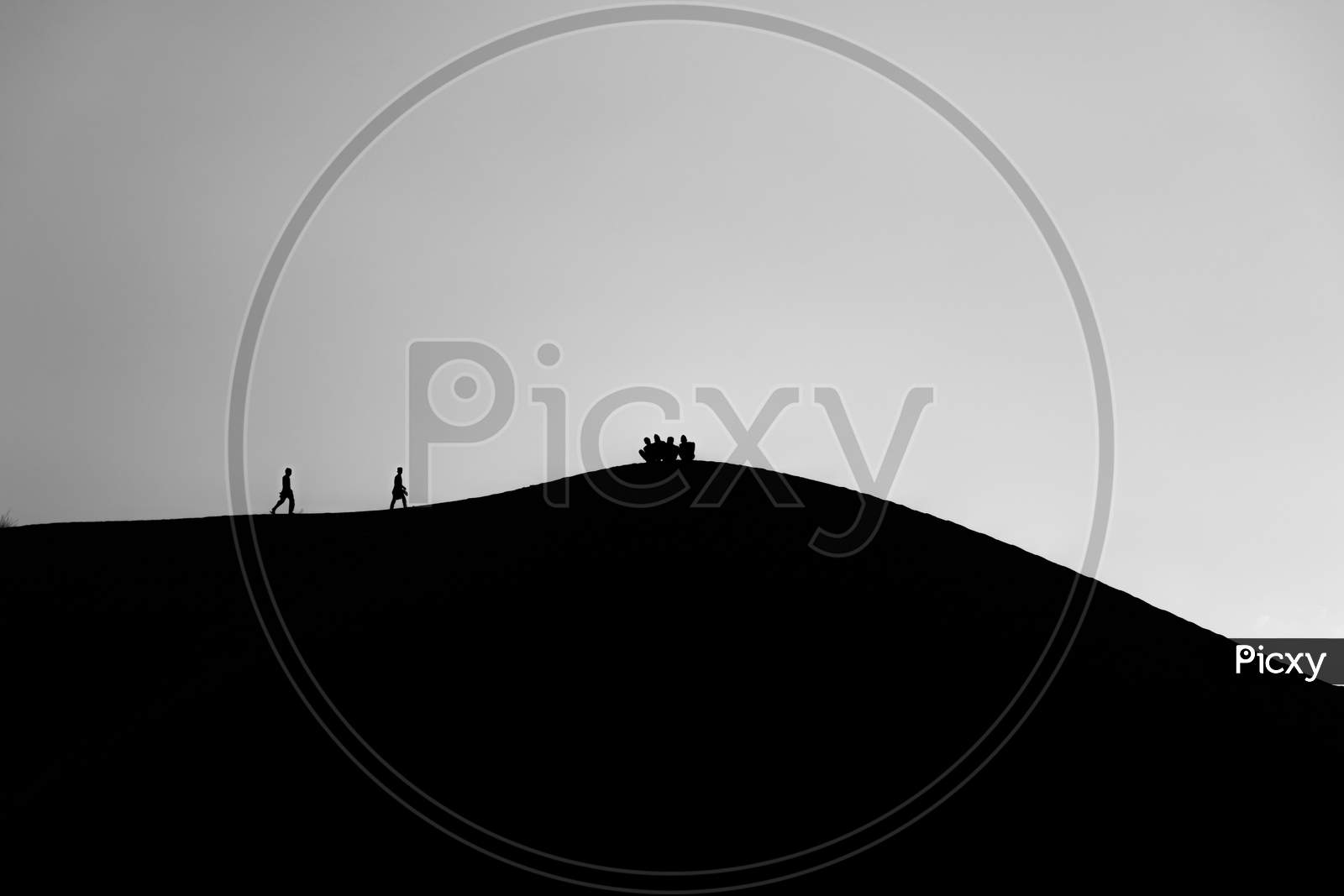 black and white picture of People walking on desert in silhouette