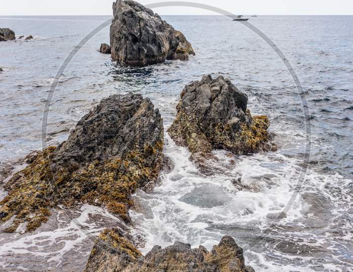 Italy, Cinque Terre, Manarola, A Rocky Beach Next To A Body Of Water