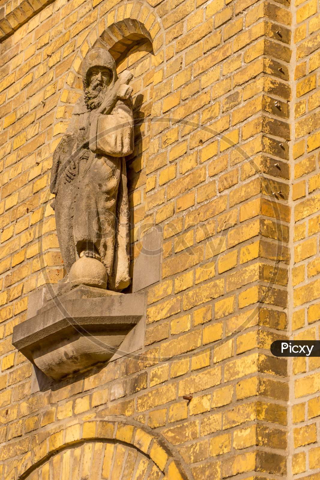Belgium, Bruges, A Close Up Of A Christian Statue On A Reb Brick Building