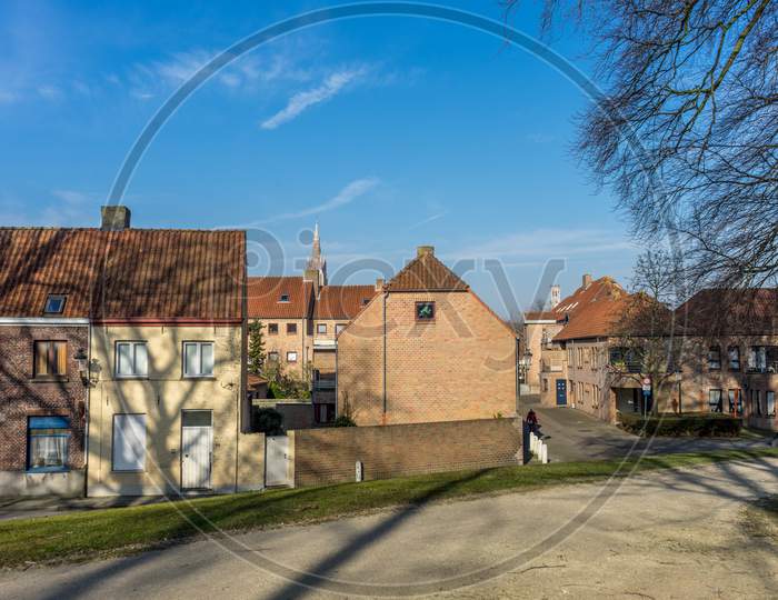 Belgium, Bruges, A Large Brick Building With Grass In Front Of A House