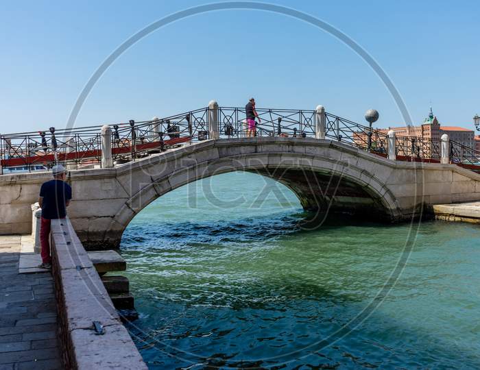 Venice, Italy - 01 July 2018: People Walking On The Bridge Over The Canal In Venice, Italy