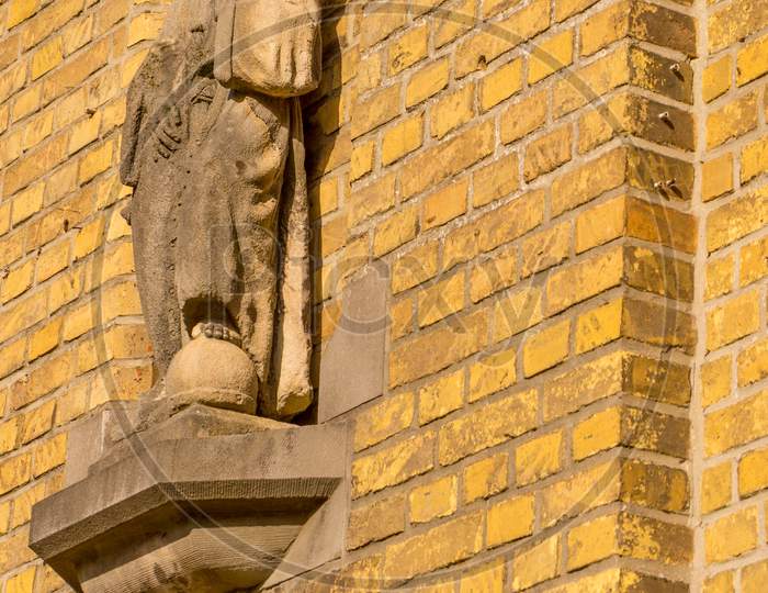 Belgium, Bruges, A Close Up Of A Christian Statue On A Reb Brick Building