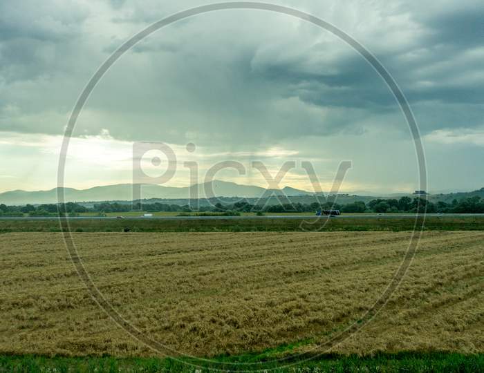 Italy, Rome To Florence Train, A Field With Clouds In The Sky