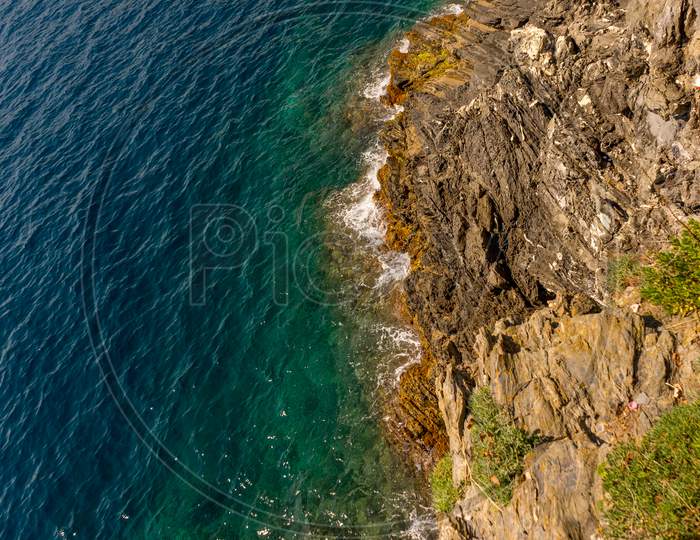 Italy, Cinque Terre, Manarola, A Close Up Of A Rock Next To A Body Of Water