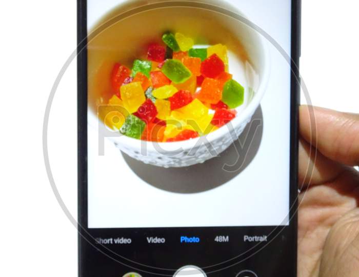 cute little candy in a white bowl with white background mobile