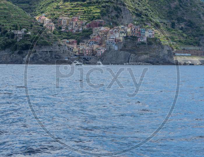 Italy, Cinque Terre, Monterosso, A Large Body Of Water With A Mountain In The Background
