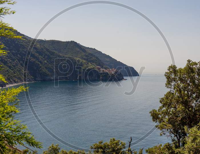 Italy, Cinque Terre, Corniglia, A Large Body Of Water Surrounded By Trees