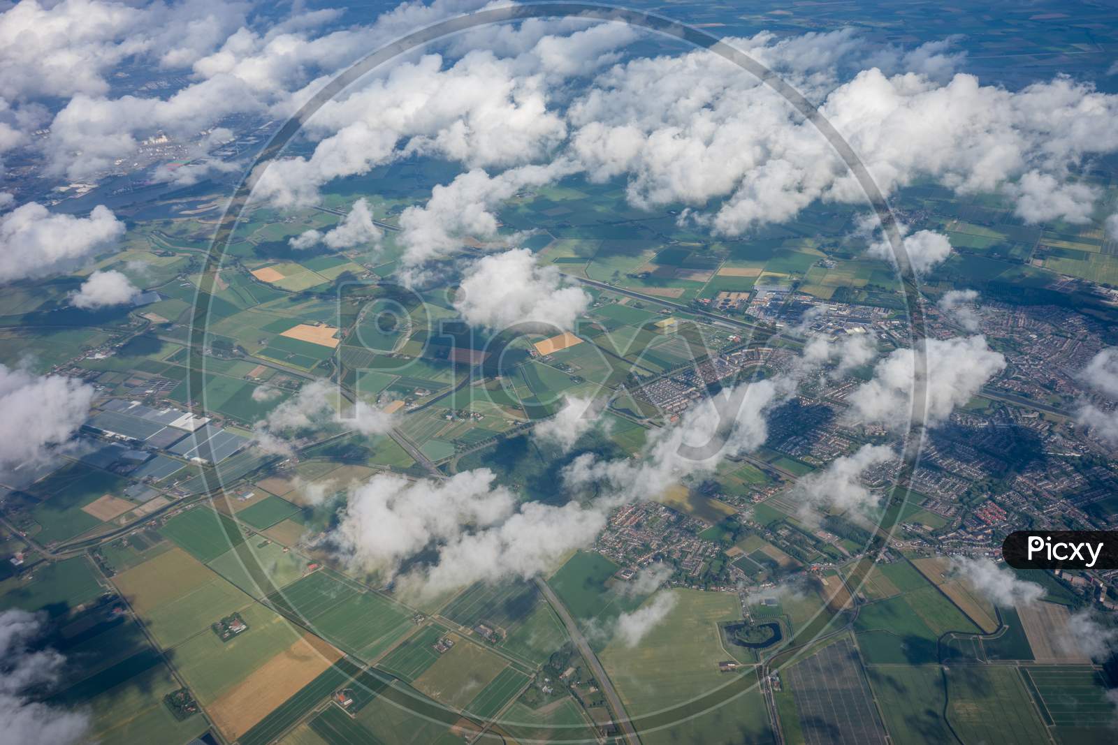 Farms In Holland, Netherlands With Canal Viewed From Plane In Sky With Clouds