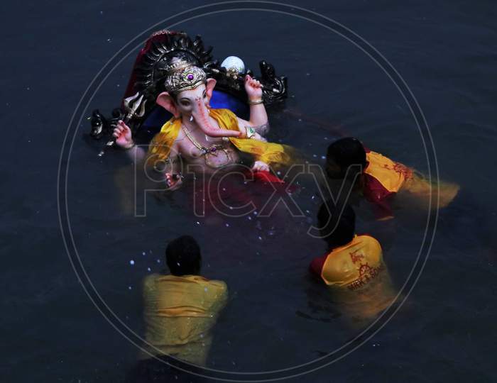 Volunteers immerse an idol of Hindu God Ganesha, in the Arabian Sea, marking the end of the 10-day long Ganesh Chaturthi festival at the Gateway of India, in Mumbai, India on September 1, 2020.