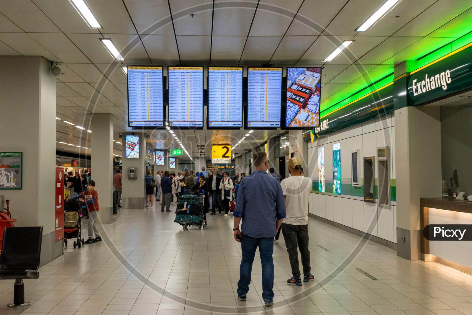 Netherlands, Amsterdam, Schiphol - 06 May, 2018:  People Reading A Display Screen At The Airport