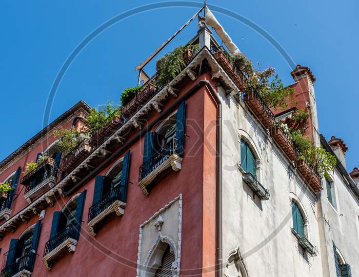 Italy, Venice, A Large Brick Tower With A Clock On The Side Of A Building