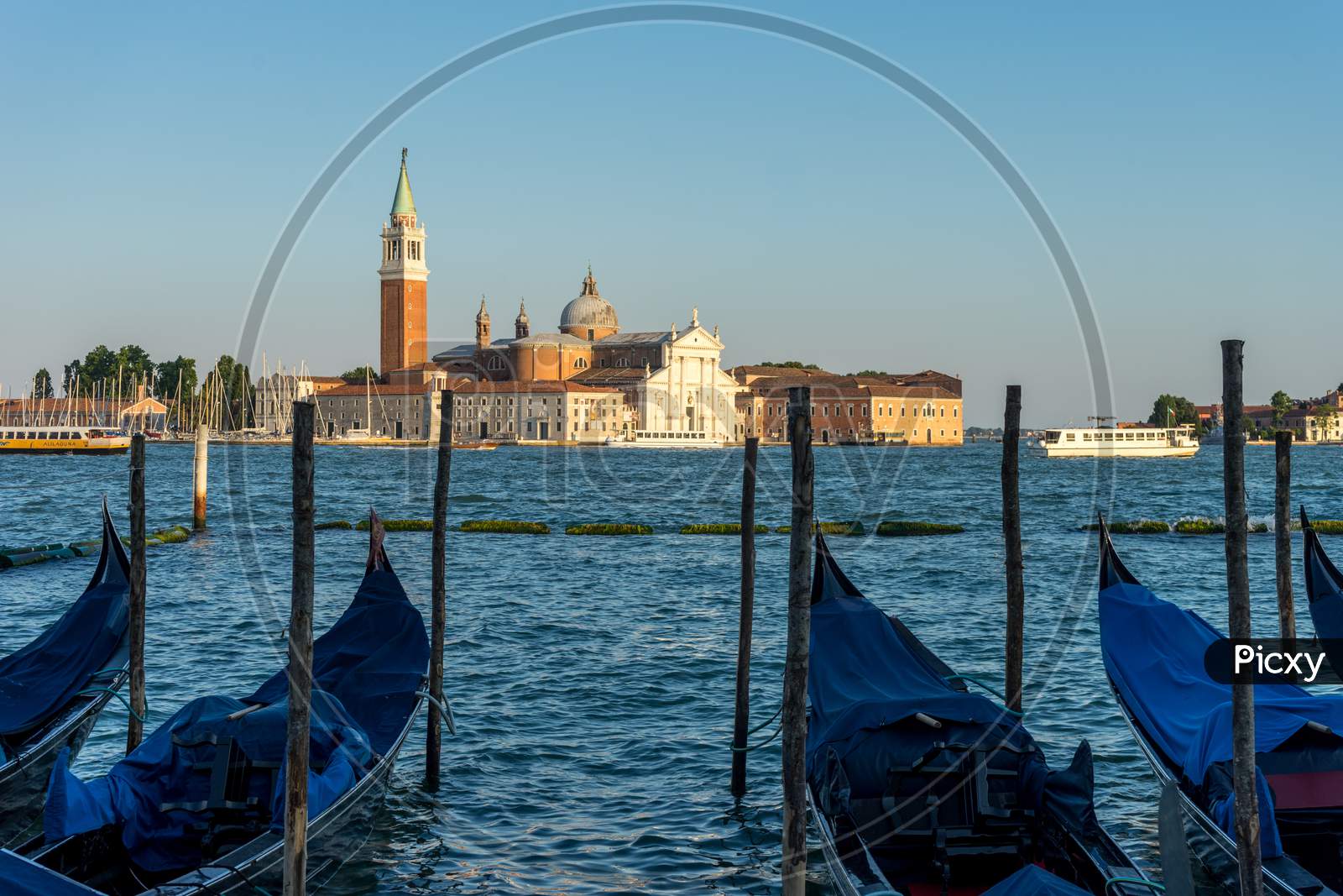 Venice, Italy - 30 June 2018: Gondolas Moored By Saint Mark Square With San Giorgio Di Maggiore Church In The Background In Venice, Italy