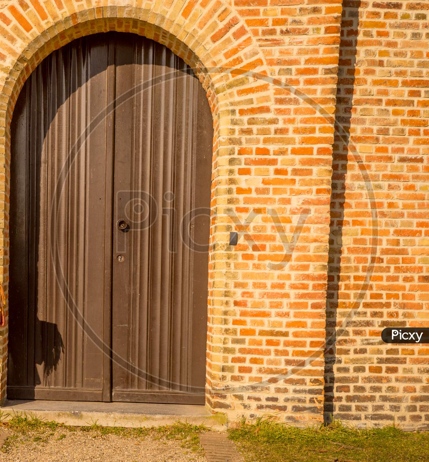 Belgium, Bruges, A Wooden Door In Front Of A Brick Building