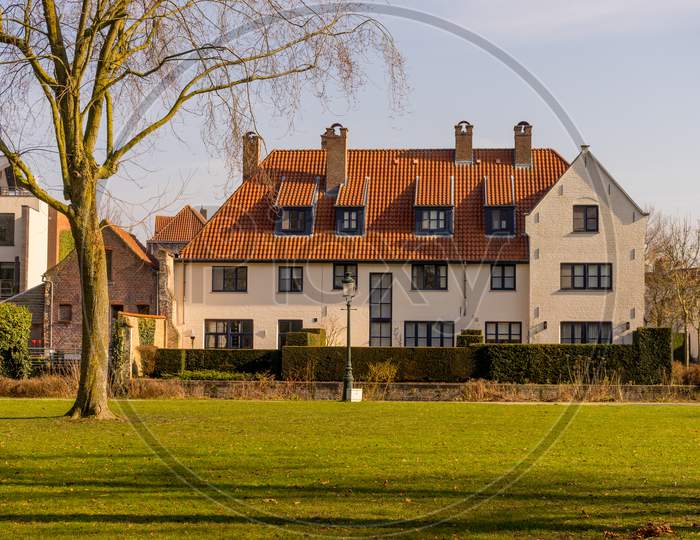 Belgium, Bruges, A Close Up Of A Green Field In Front Of A House