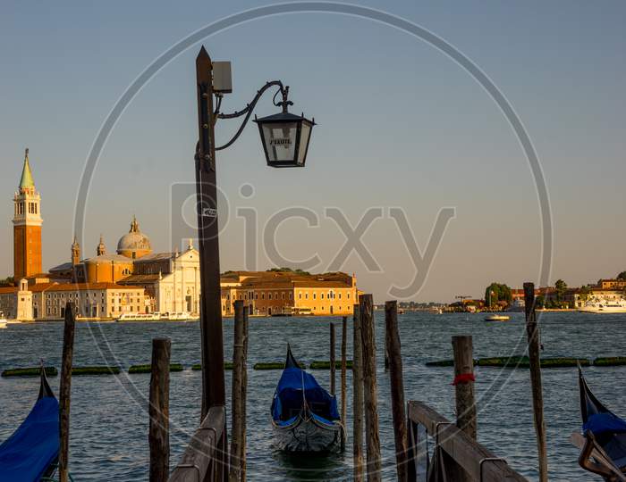 Gondolas Moored By Saint Mark Square With San Giorgio Di Maggiore Church In The Background In Venice, Italy