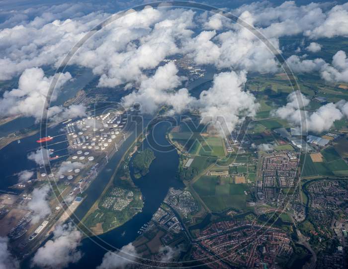 Windmill Farms In Holland, Netherlands With Canal Viewed From Plane In Sky With Clouds