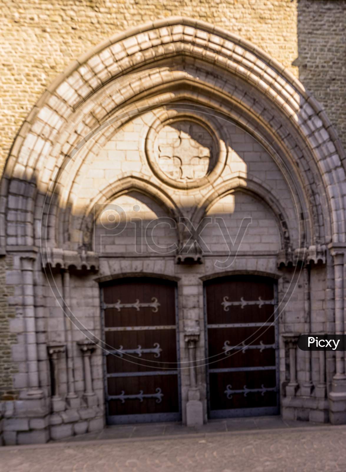 Belgium, Bruges, Wooden Door Under A Stone Archway