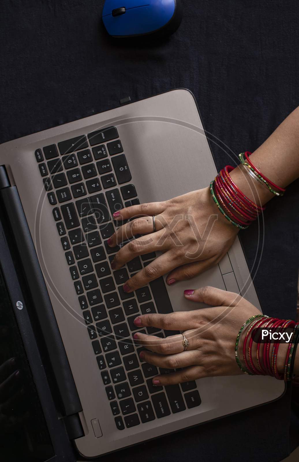 Female Wearing Bangles And Working On Laptop.