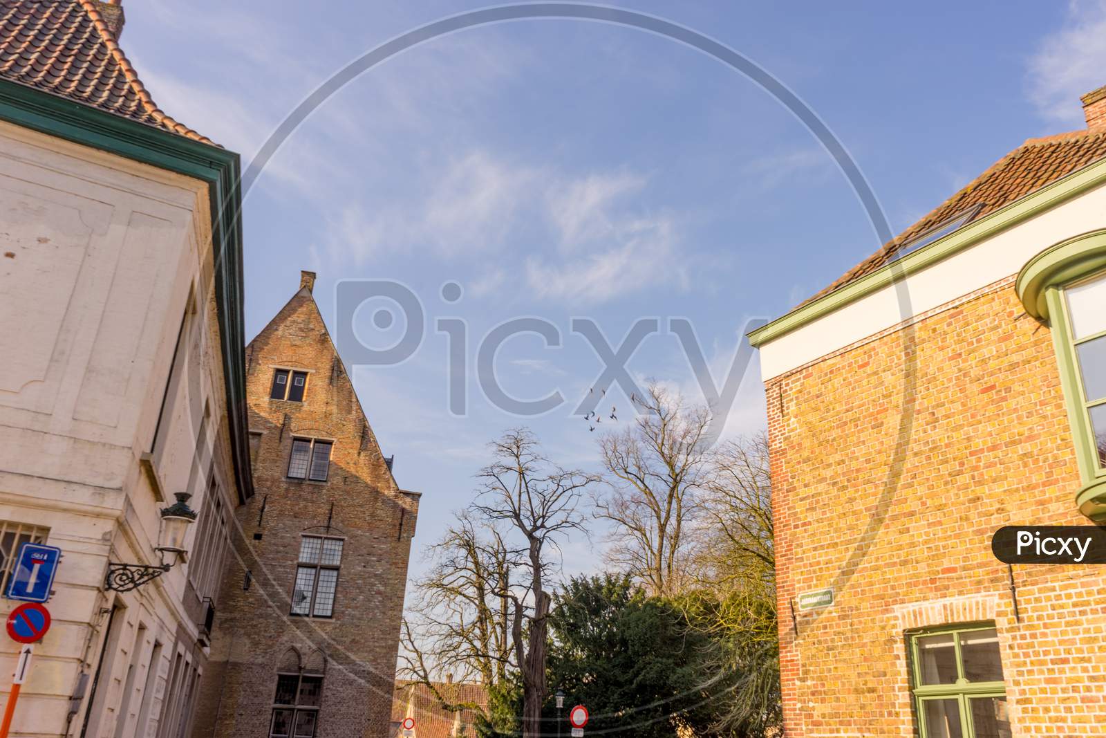 Belgium, Bruges, A Clock Tower In Front Of A Brick Building