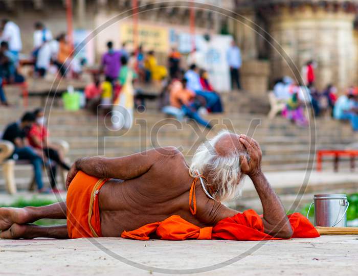 A monk is laying on the ghat and watching the couples