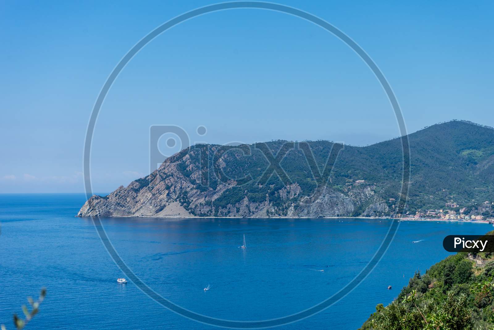 Italy, Cinque Terre, Corniglia, A Body Of Water With A Mountain In The Background