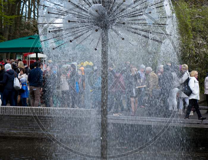 Lisse, Netherlands - April 17 : The Keukenhoff Tulip Gardens On April 17, 2016. Tourists Gather Near The Water Fountain