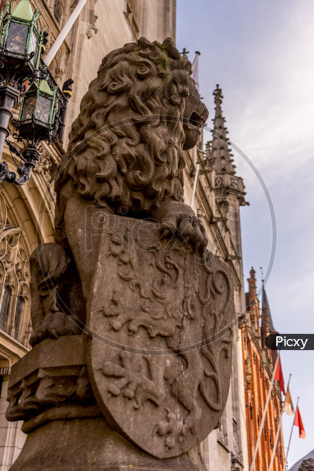 Belgium, Bruges, A Lion Statue With Shield Sitting On The Side Of A Building