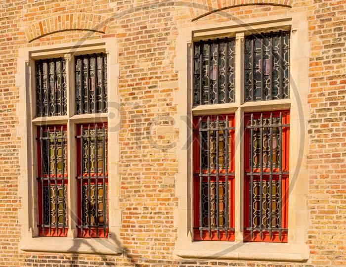 Belgium, Bruges, A Close Up Of A Brick Building With Grilled Windows