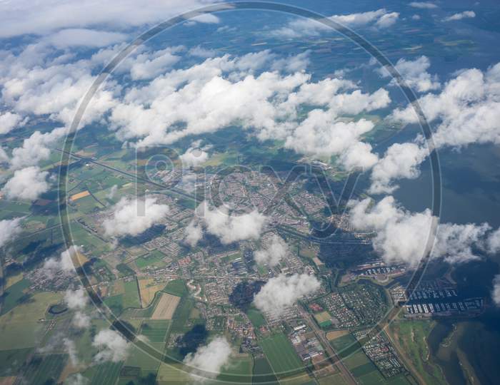Farms In Holland, Netherlands With Canal Viewed From Plane In Sky With Clouds