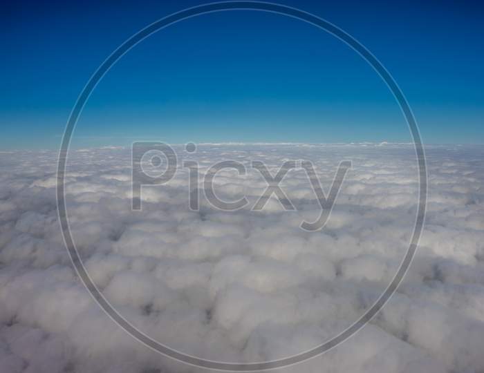 Clouds In The Sky Viewed From A Plane Against A Blue Sky