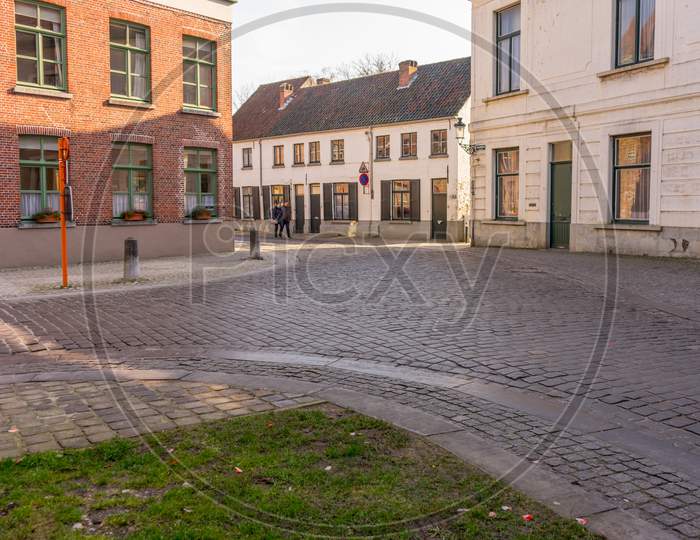 Belgium, Bruges, A Close Up Of A Street In Front Of A Brick Building