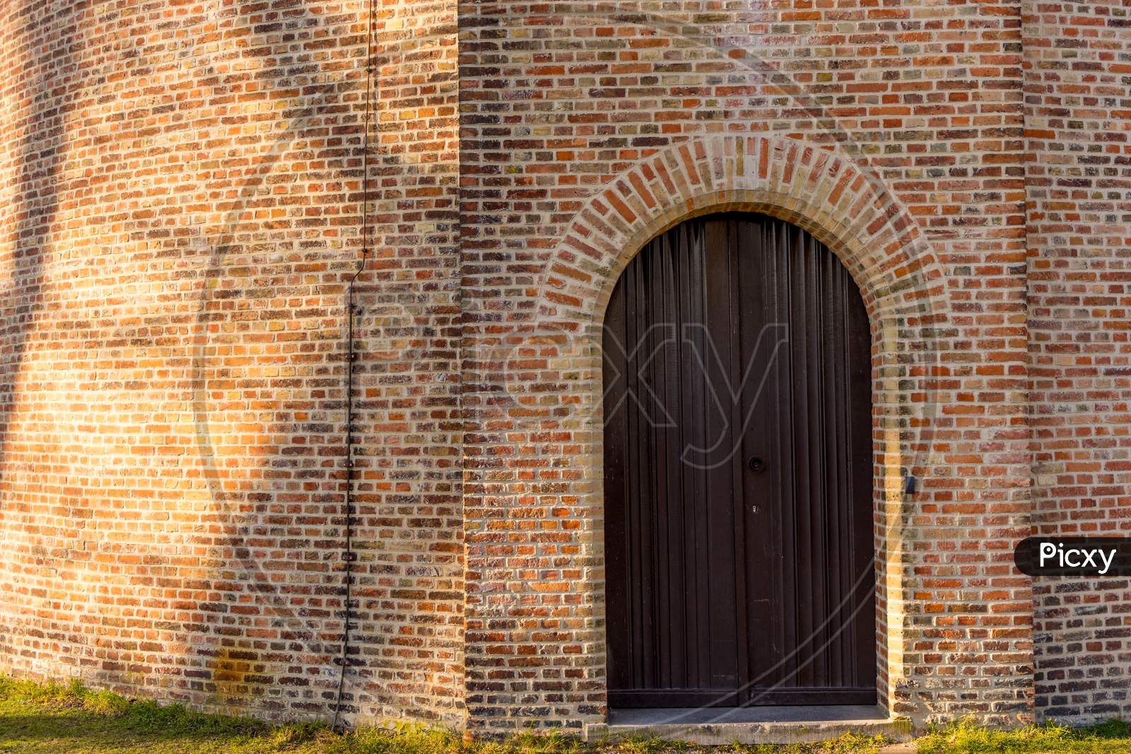 Belgium, Bruges, Entrance Under Arch Of An Old Brick Building