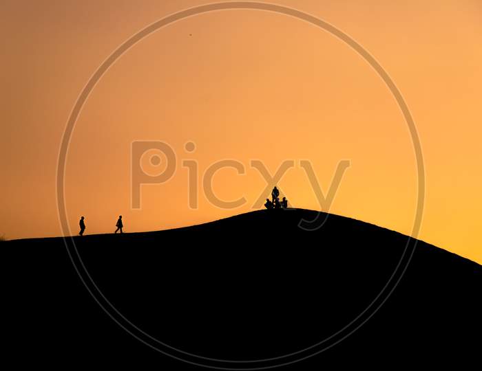 People walking on desert in silhouette