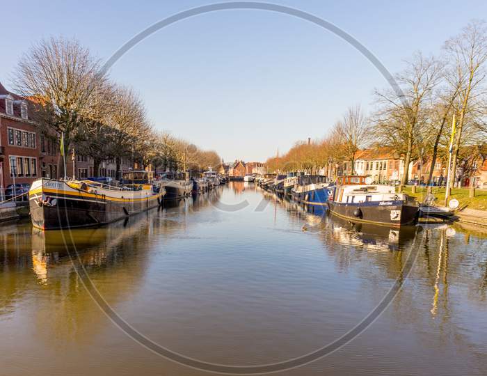 Bruges, Belgium - 17 February 2018: Boats Are Docked On A Canal In Brugge/Bruges Belgium