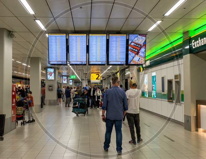 Netherlands, Amsterdam, Schiphol - 06 May, 2018:  People Reading A Display Screen At The Airport