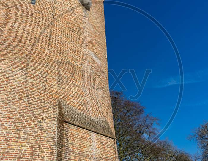 Belgium, Bruges, A Large Brick Tower With A Clock On The Side Of A Building