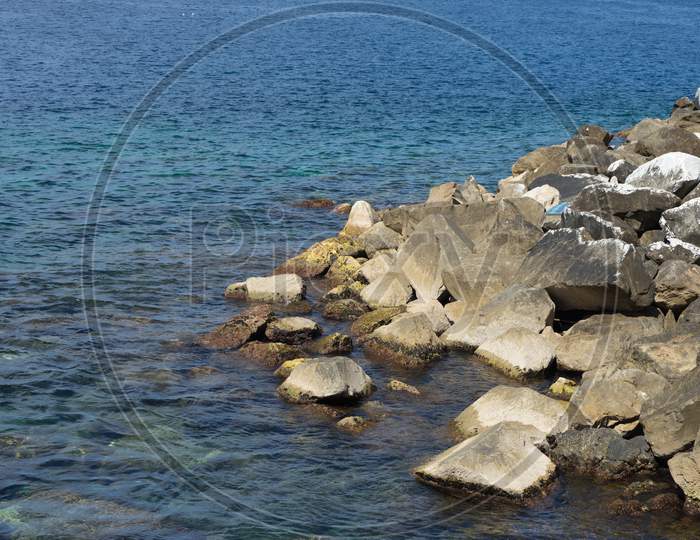 Italy,Cinque Terre,Riomaggiore, A Rocky Beach Next To A Body Of Water
