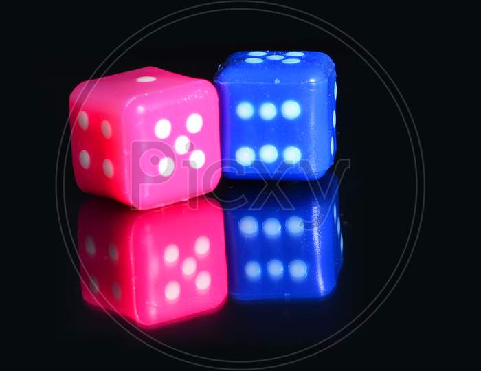 Multi Color Dice Placed On A Reflecting Surface.