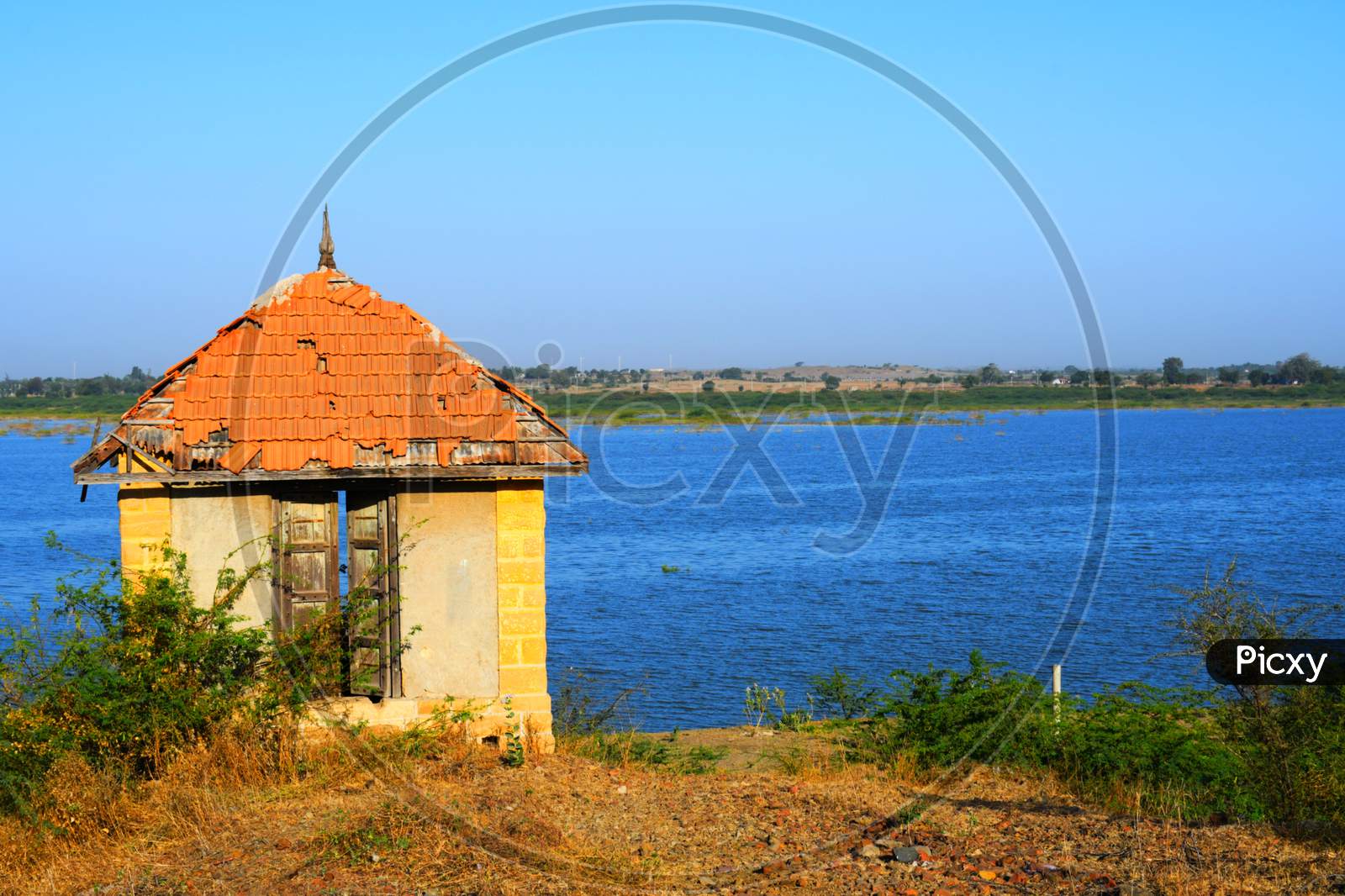 Hut on banks of the river of India, old hut, Little old house on banks of the river at sunset in silence